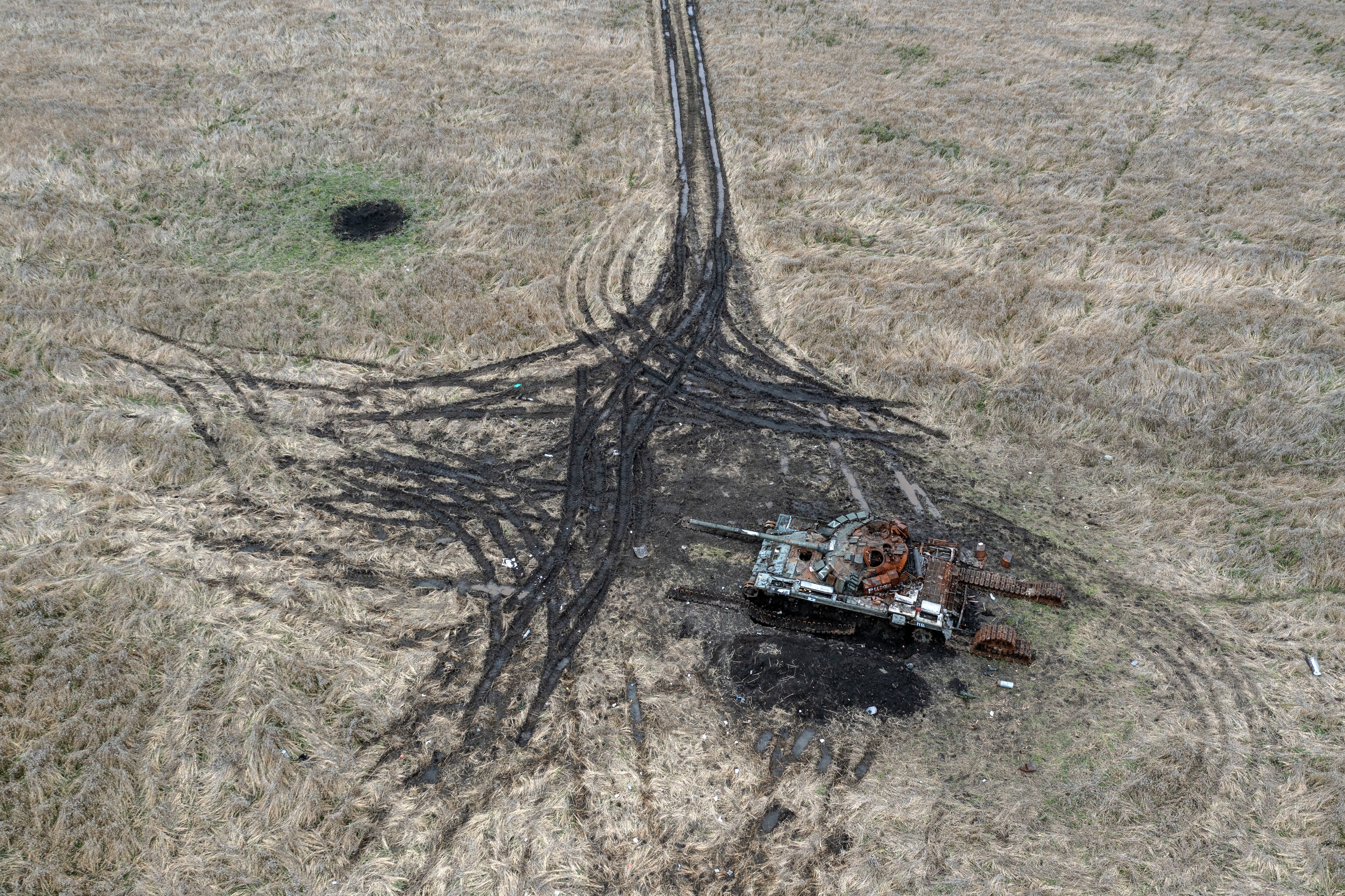 Artillery and mortar craters pierce the ground next to a destroyed Russian tank on Oct. 23, 2022 in Kam'yanka, Kharkiv oblast, Ukraine.